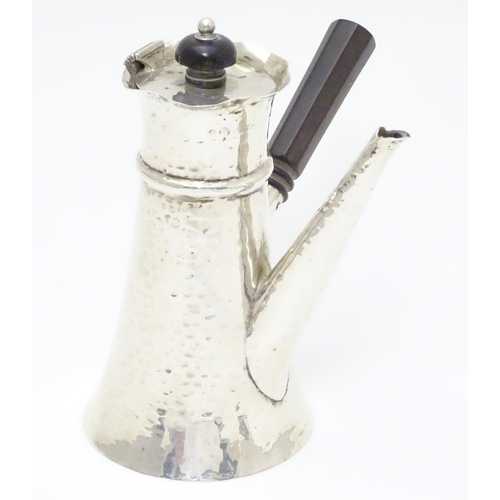 231 - A silver chocolate pot with hammered decoration and ebonised handle. Hallmarked London 1909 maker Jo... 