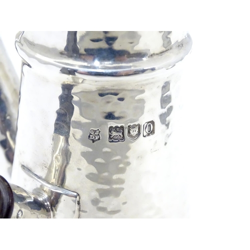 231 - A silver chocolate pot with hammered decoration and ebonised handle. Hallmarked London 1909 maker Jo... 