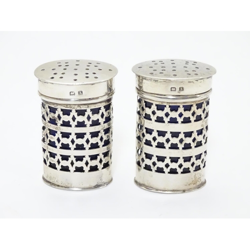 237 - A pair silver mounted pepperettes of ovoid form with blue glass liners, hallmarked Birmingham 1922 m... 