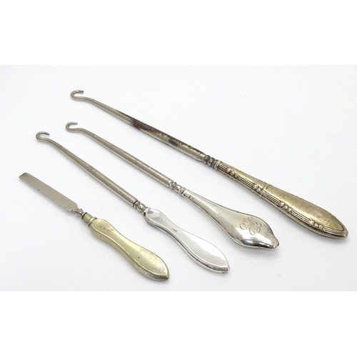 241 - Three assorted button hooks with silver handles together with a manicure tool. The largest 8 3/4