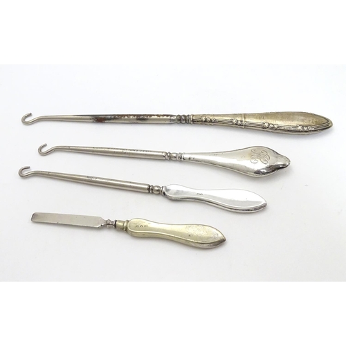 241 - Three assorted button hooks with silver handles together with a manicure tool. The largest 8 3/4