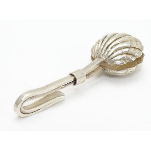 242 - A white metal napkin clip with scallop shell formed grips. 2