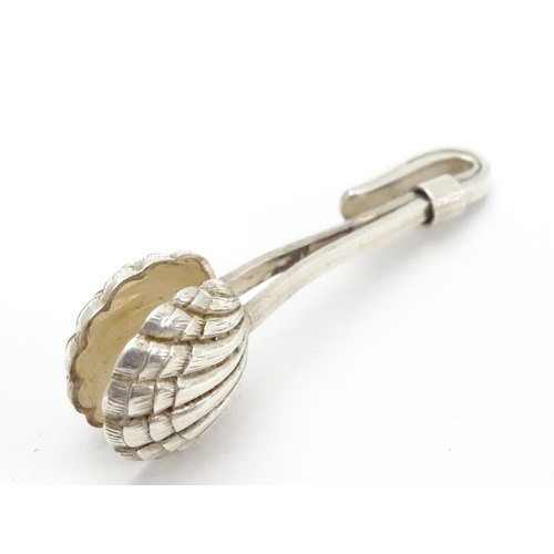 242 - A white metal napkin clip with scallop shell formed grips. 2