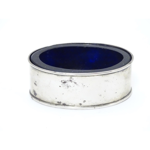 245 - A silver salt of oval form with blue glass liner.  Hallmarked 1919 maker William Aitken.  2 1/4