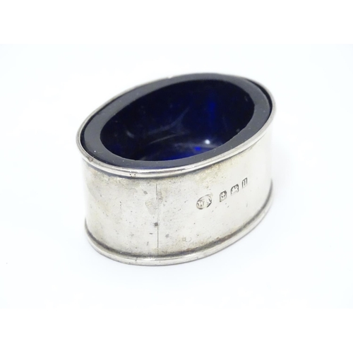 245 - A silver salt of oval form with blue glass liner.  Hallmarked 1919 maker William Aitken.  2 1/4