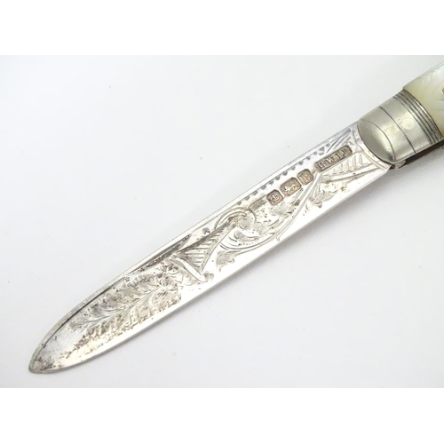 273 - A silver folding fruit knife with mother of pearl handle having engraved decoration.  Hallmarked She... 