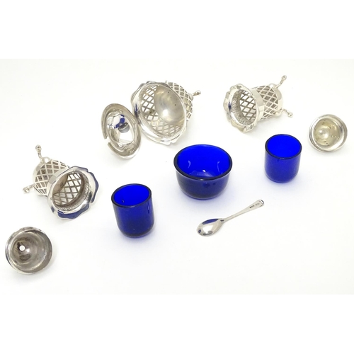 278 - A silver three piece cruet set with pierced lattice decoration. With blue glass liners and associate... 