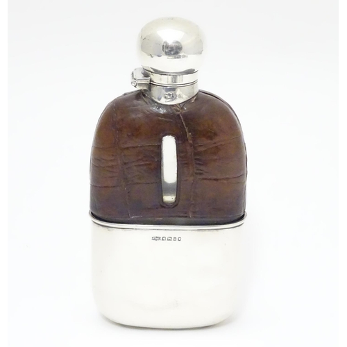 279 - A Victorian glass hip flask with half leather covering, silver beaker lower and silver mounts. Hallm... 