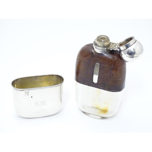 279 - A Victorian glass hip flask with half leather covering, silver beaker lower and silver mounts. Hallm... 