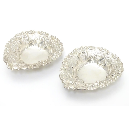 286 - A pair of late Victorian silver heart-shaped bonbon dishes with pierced and scroll decoration, each ... 