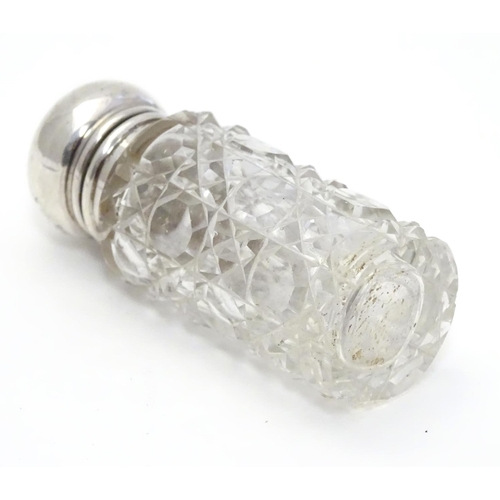 346 - A cut glass scent / perfume bottle with silver mount and lid, hallmarked  Birmingham 1913. 2 1/2