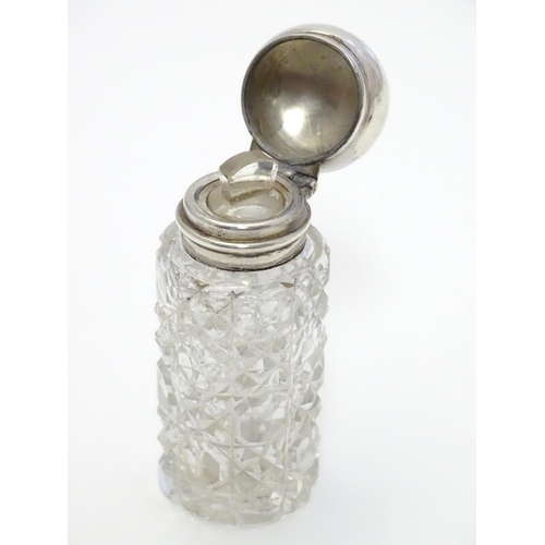 346 - A cut glass scent / perfume bottle with silver mount and lid, hallmarked  Birmingham 1913. 2 1/2