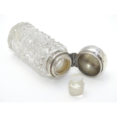 346 - A cut glass scent / perfume bottle with silver mount and lid, hallmarked  Birmingham 1913. 2 1/2