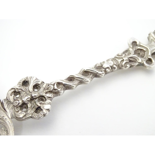 348 - An ornate silver strainer / sifter spoon with figural detail to handle and floral and acanthus detai... 