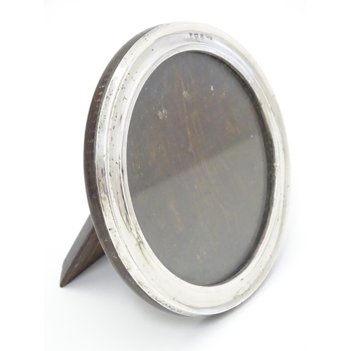 355 - A photograph frame of circular form with silver surround hallmarked Bimringhm1925 maker Sanders & Ma... 