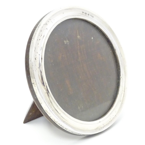 355 - A photograph frame of circular form with silver surround hallmarked Bimringhm1925 maker Sanders & Ma... 