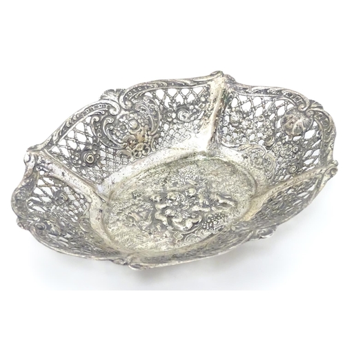 356 - A Continental silver dish of basket form with lattice decoration and cast cherub scene. 7 1/4