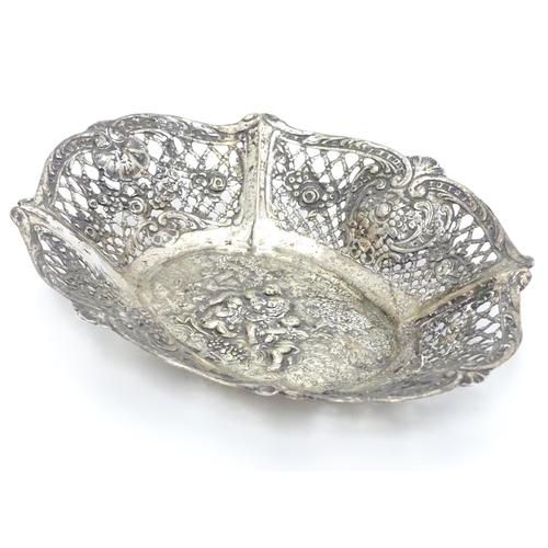 356 - A Continental silver dish of basket form with lattice decoration and cast cherub scene. 7 1/4