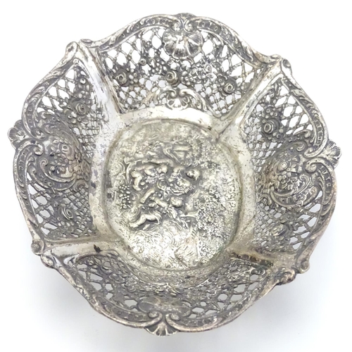 356 - A Continental silver dish of basket form with lattice decoration and cast cherub scene. 7 1/4