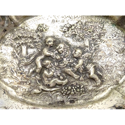 356 - A Continental silver dish of basket form with lattice decoration and cast cherub scene. 7 1/4