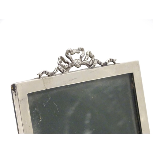 363 - A photograph frame with silver surround and ribbon cresting. Hallmarked Birmingham 1908 maker E Mand... 