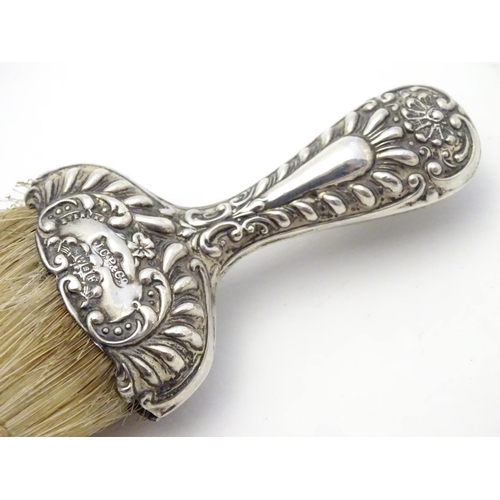 364 - A silver handled hat brush with embossed decoration. Hallmarked Chester 1902 maker J C Plimpton & Co