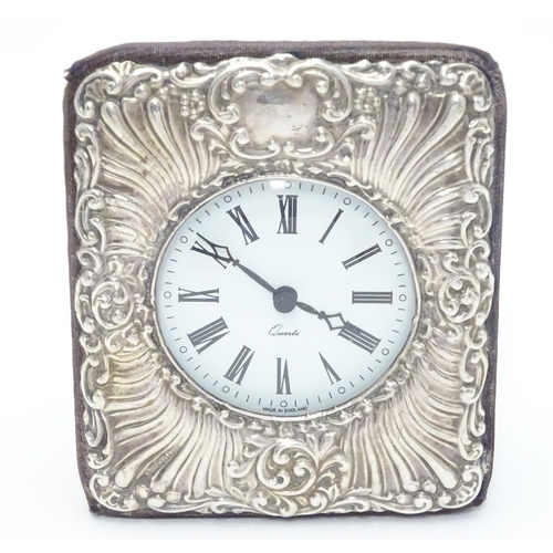 377 - An easel back clock with silver surround. Hallmarked London 1990 maker Keyford Frames Ltd. 4 1/2