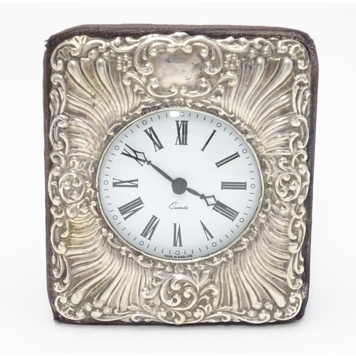 377 - An easel back clock with silver surround. Hallmarked London 1990 maker Keyford Frames Ltd. 4 1/2