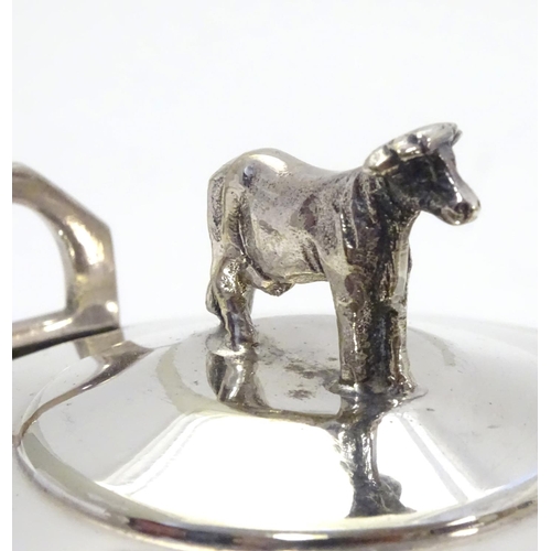 379 - A silver plate butter dish of circular form with glass liner, the lid with cow formed finial. 4