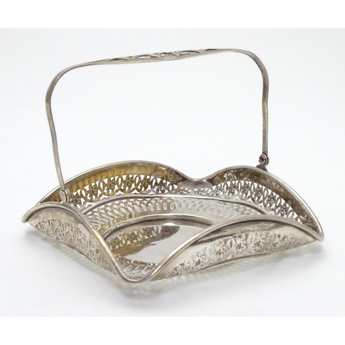 382 - An American Sterling silver swing-handled bonbon dish of square form with pierced decoration. Maker’... 