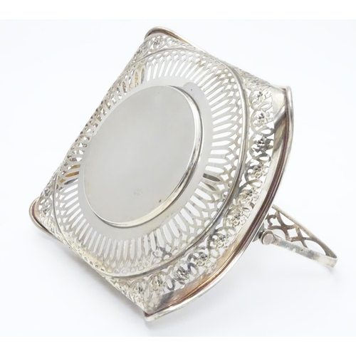 382 - An American Sterling silver swing-handled bonbon dish of square form with pierced decoration. Maker’... 