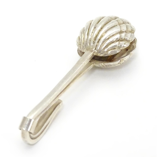 389 - A white metal napkin clip with scallop shell formed grips. 2