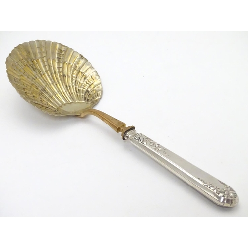 399 - A French silver handled serving spoon with foliate decoration to the handle and a scallop formed gil... 