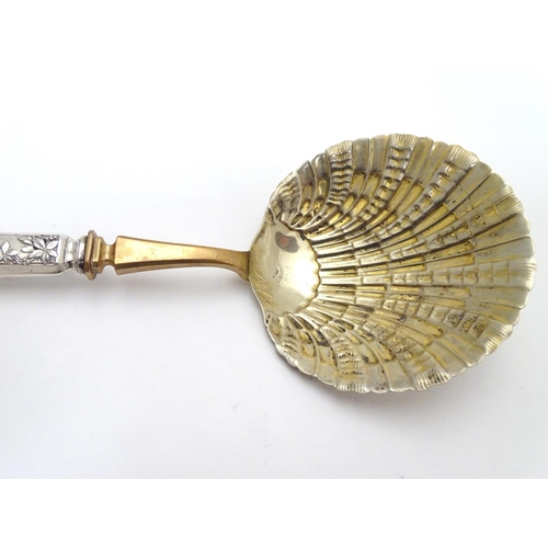 399 - A French silver handled serving spoon with foliate decoration to the handle and a scallop formed gil... 