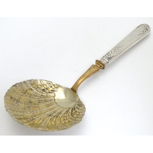 399 - A French silver handled serving spoon with foliate decoration to the handle and a scallop formed gil... 