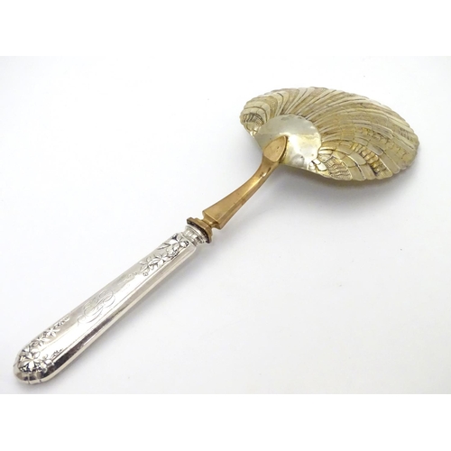 399 - A French silver handled serving spoon with foliate decoration to the handle and a scallop formed gil... 