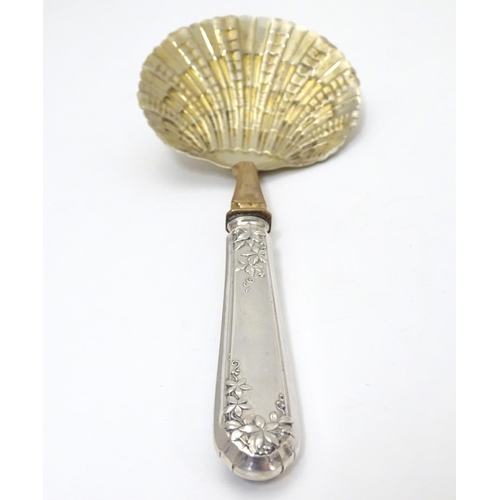 399 - A French silver handled serving spoon with foliate decoration to the handle and a scallop formed gil... 