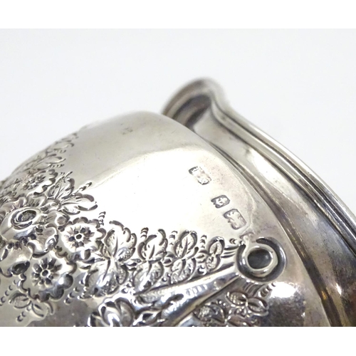 409 - A silver cream jug decorated with floral swags and with part gilded interior. Hallmarked Birmingham ... 