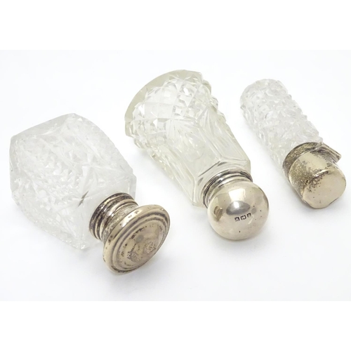 415A - 3 various cut glass perfume / scent bottles with silver tops. The tallest 3 1/2