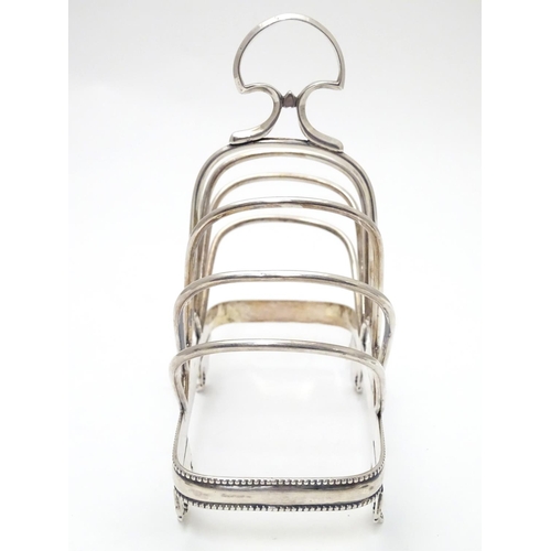 417 - A silver plate 7 bar toast / letter rack  with loop handle. Indistinctly marked with registration di... 