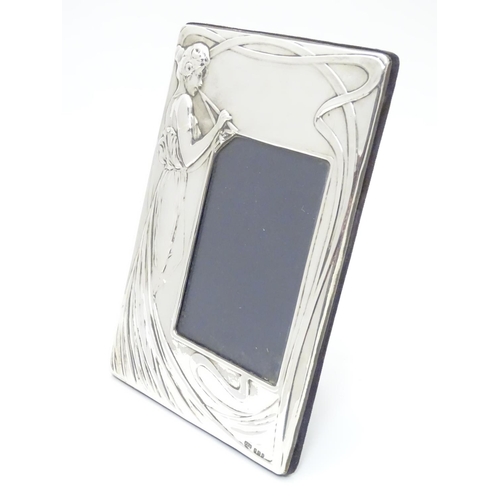 424 - A photograph frame with silver surround with Art Nouveau style decoration. Hallmarked Birmingham 198... 