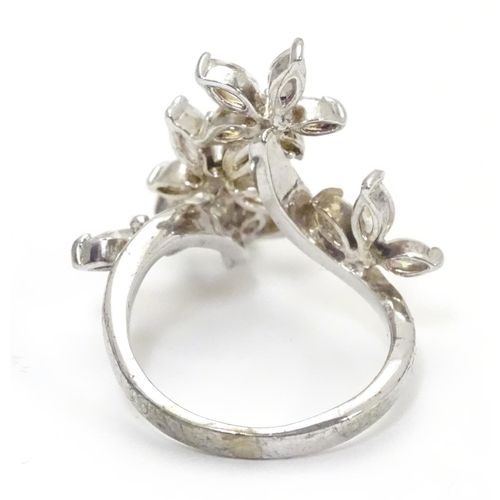 442 - A silver dress ring with white stone decoration. Ring size approx O