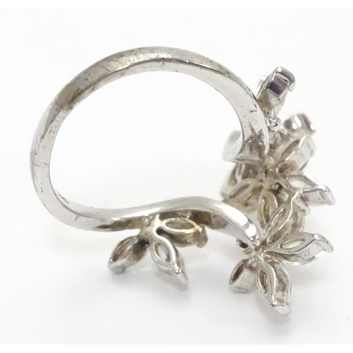 442 - A silver dress ring with white stone decoration. Ring size approx O