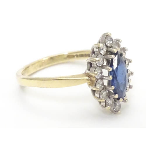 443 - A 14k gold ring set with central sapphire bordered by white stones. Ring size approx N 1/2