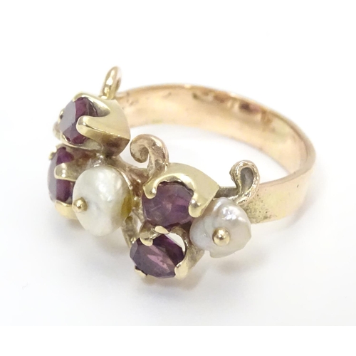 444 - A 9ct gold ring dress ring  set with 4 amethysts and two pearls. Hallmarked to outer band London 197... 