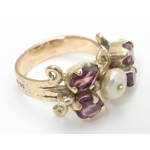 444 - A 9ct gold ring dress ring  set with 4 amethysts and two pearls. Hallmarked to outer band London 197... 