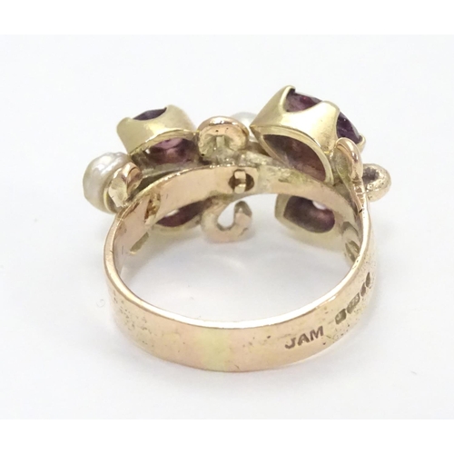 444 - A 9ct gold ring dress ring  set with 4 amethysts and two pearls. Hallmarked to outer band London 197... 