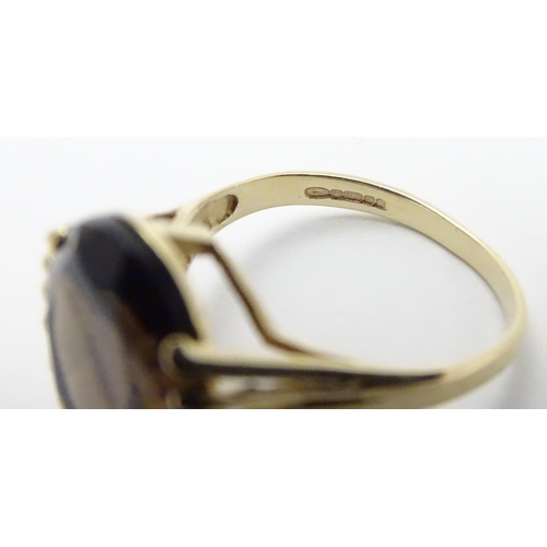 445 - A 9ct gold ring set with central oval smoky quartz in a claw setting. Ring size approx M