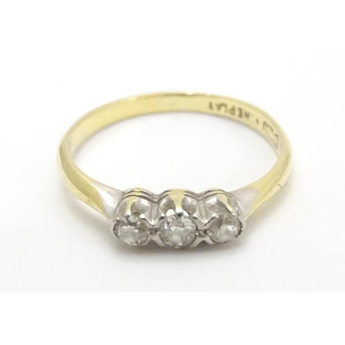 448 - An 18ct gold ring set with trio of diamonds. Ring size approx M