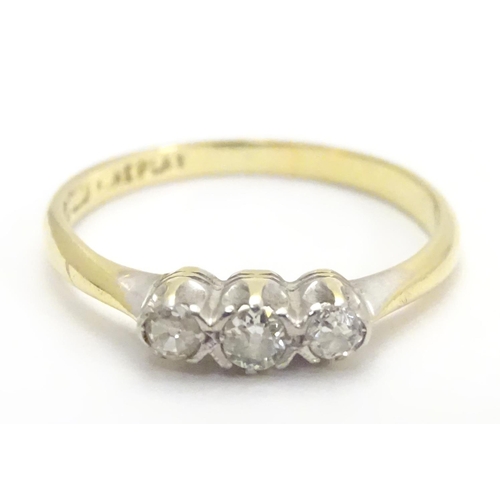 448 - An 18ct gold ring set with trio of diamonds. Ring size approx M